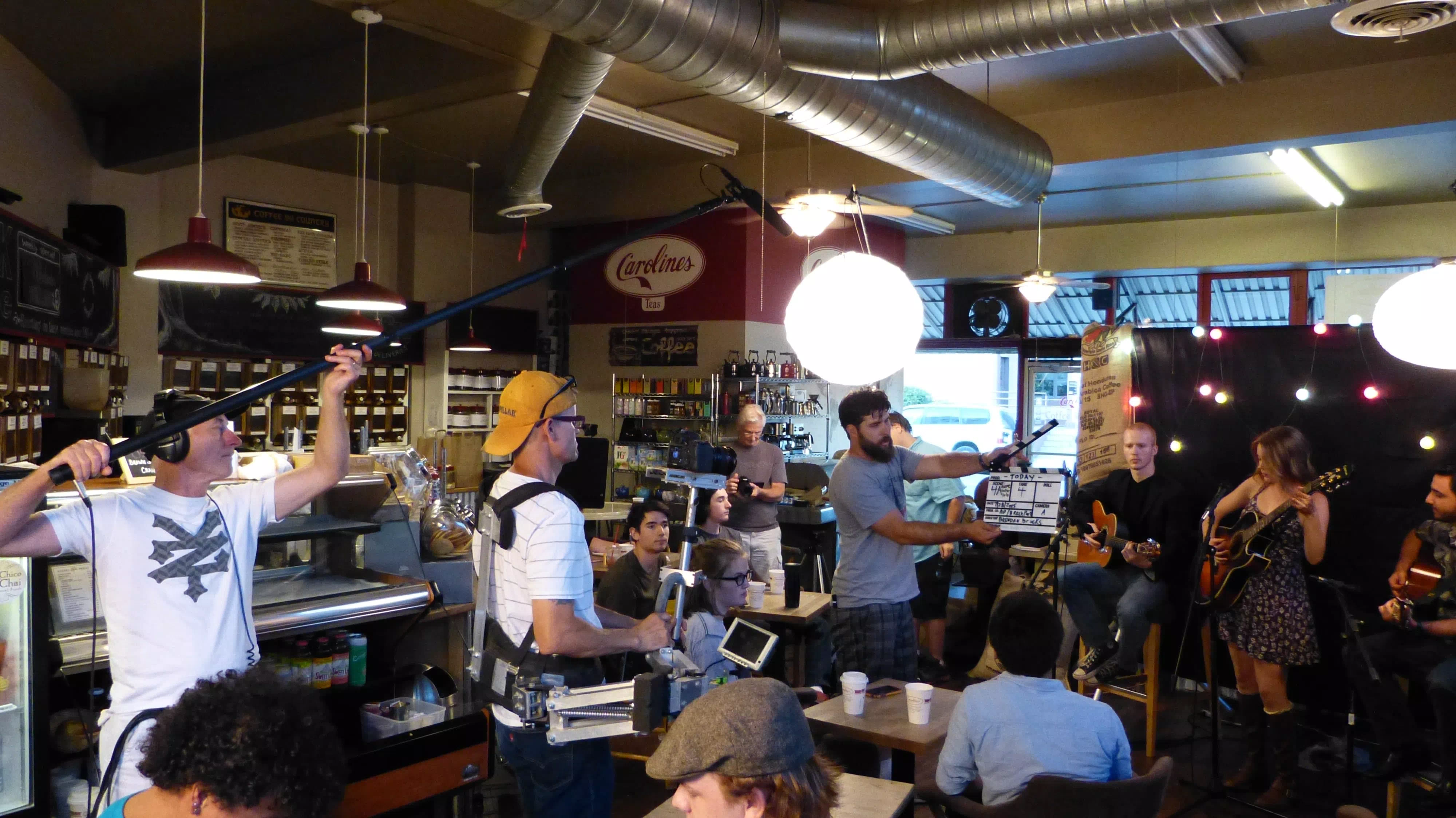 The movie TODAY on location at Carolines Coffee Roasters in Grass Valley, California - the whole set with the cast and crew Hayley Pritchard playing guitar in front of a crowd.